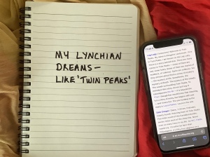 Twin Peaks quote from Wikipedia on a smartphone beside a spiral diary with handwritten text.